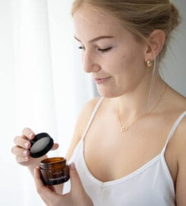 a woman holding a jar of cream