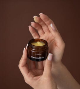 a person holding a jar of cream