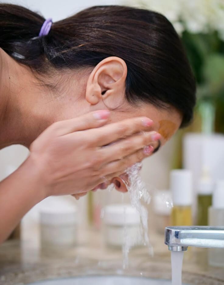a woman washing her face