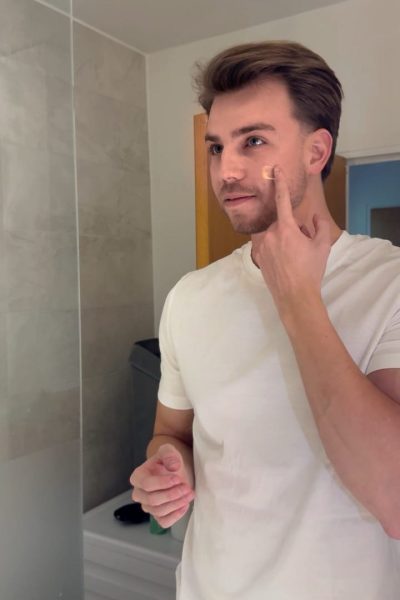 a man putting on a cream on his face